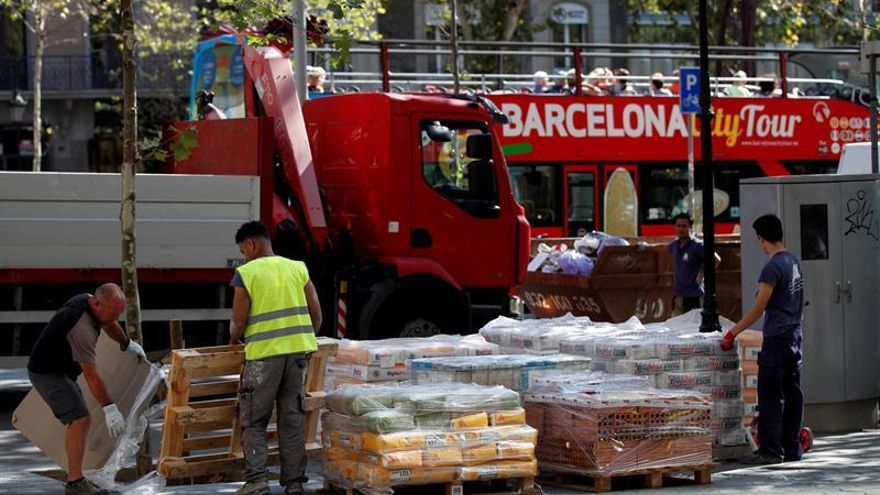 Varios operarios trabajan en una céntrica calle de Barcelona este martes poco después de conocerse que el número de parados registrados en las oficinas del Servicio Público de Empleo Estatal (SEPE) aumentó en agosto en 54.371 personas respecto a julio, el mayor incremento en ese mes desde 2010.