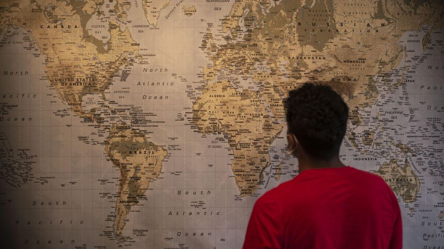 Hasan observa un mapamundi en su casa de Vigo.