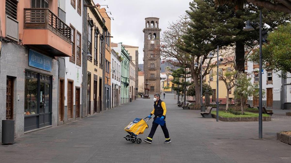 Un empleado de Correos realiza su trabajo con la torre de la iglesia de la Concepción de fondo en La Laguna este miercoles de la tercera semana del estado de alarma decretado por el Gobierno central para frenar el coronavirus.