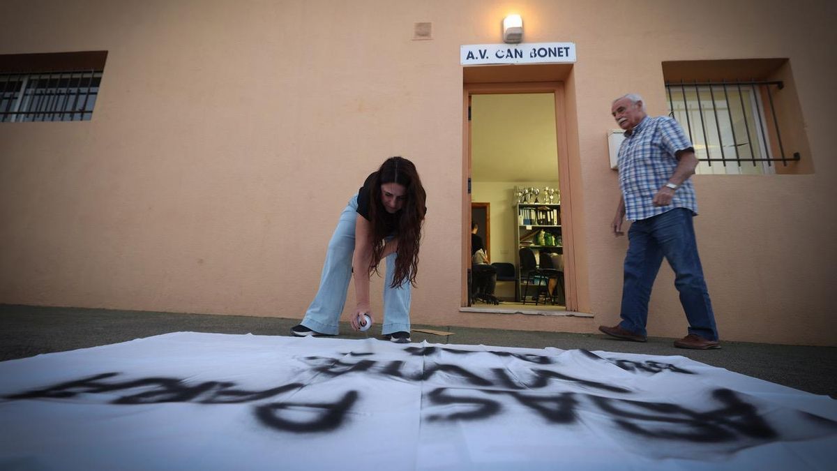 María José Torres escribe en una sábana frente al local de la asociación de vecinos que preside