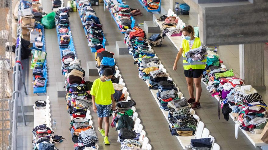 Varias personas colaboran y apilan ropa y objetos en el Polideportivo Severo Rodríguez, donde se almacenan donaciones para los afectados por la erupción del volcán de Cumbre VIeja / Kike Rincón