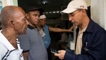 Un funcionario de la Junta Central Electoral (JCE) anuncia este domingo a los votantes que esperan en fila, que se suspenden las elecciones municipales.