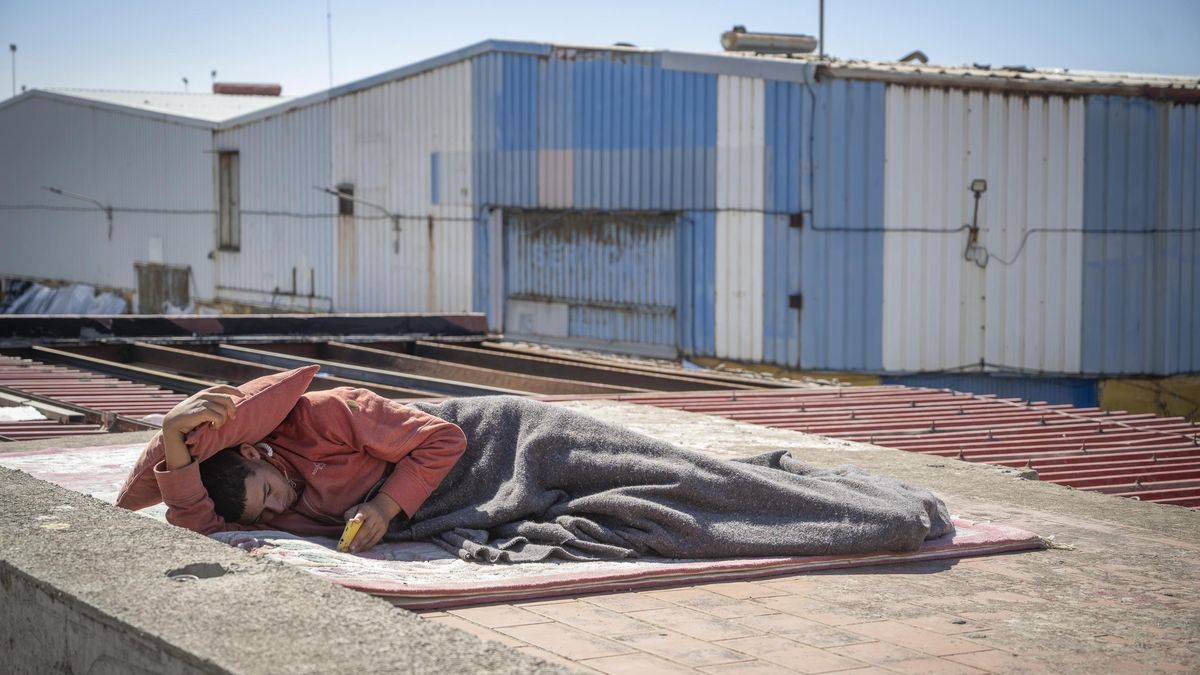 Migrante descansa sobre el techo de una nave del polígono industrial de El Tarajal, a 28 de agosto de 2026