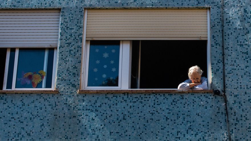 Una mujer asomada a una ventana en Barcelona, en una imagen de archivo