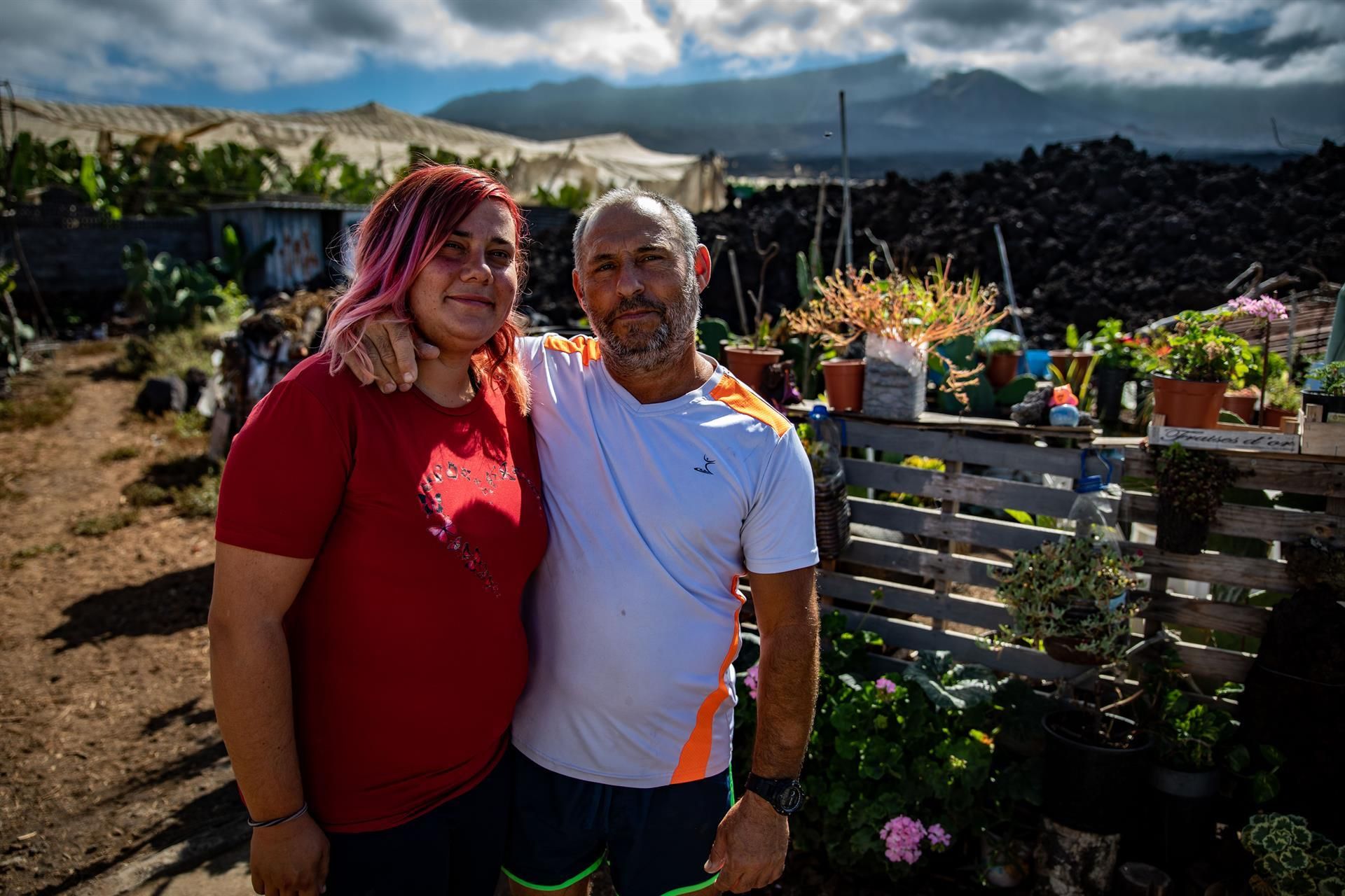 José Barreto y Naiara Sánchez posan delante de su caravana y de un pequeño jardín sobre la colada de lava en Los Llanos de Aridane.  Kike Rincón/Europa Press
