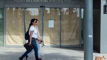 Unas jóvenes pasen un perro ante un hotel, que aún permanece cerrado, este lunes cuando la ciudad entra en la fase 1 de la desescalada, mientras el ayuntamiento refuerza los servicios municipales y pide a los ciudadanos responsabilidad y prudencia.