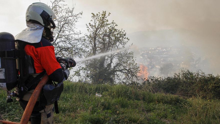 Un bombero intenta sofocar las llamas en el Monte Naranco, junto a la ciudad de Oviedo, este viernes