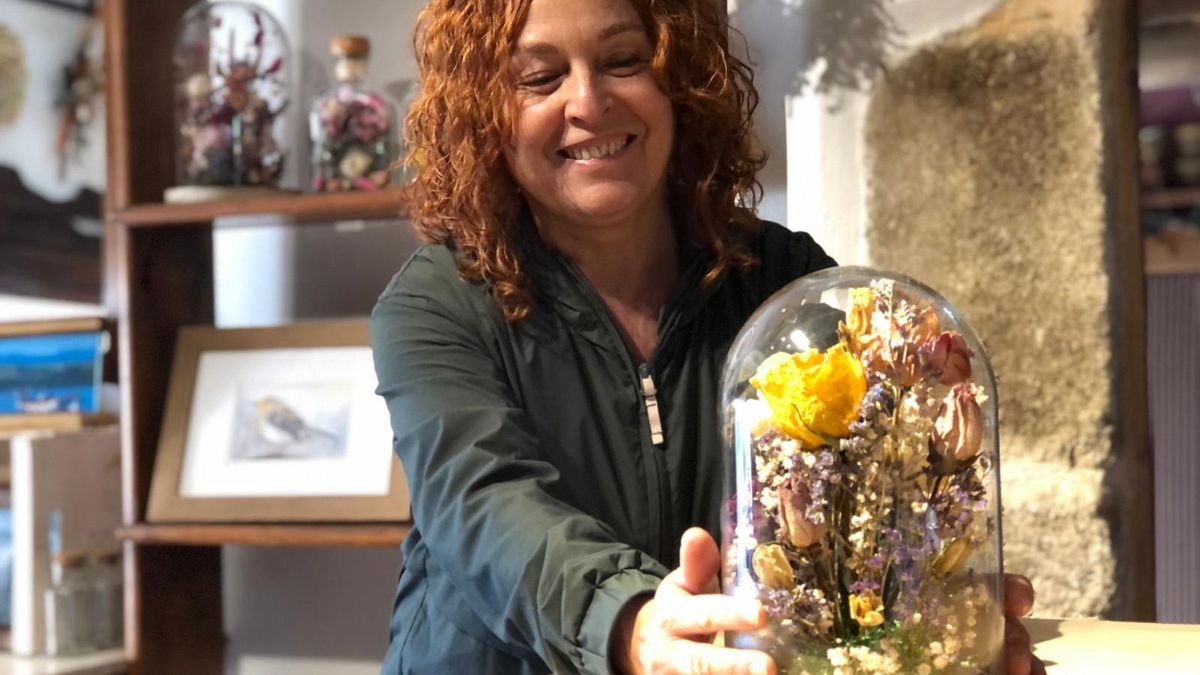 María posa junto a una de sus creaciones florales, desde su taller de Prelo, en el concejo asturiano de Boal