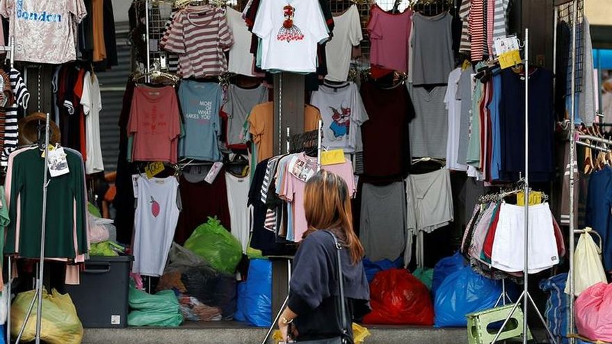 Una mujer mira unas prendas en una tienda en Bangkok (Tailandia).