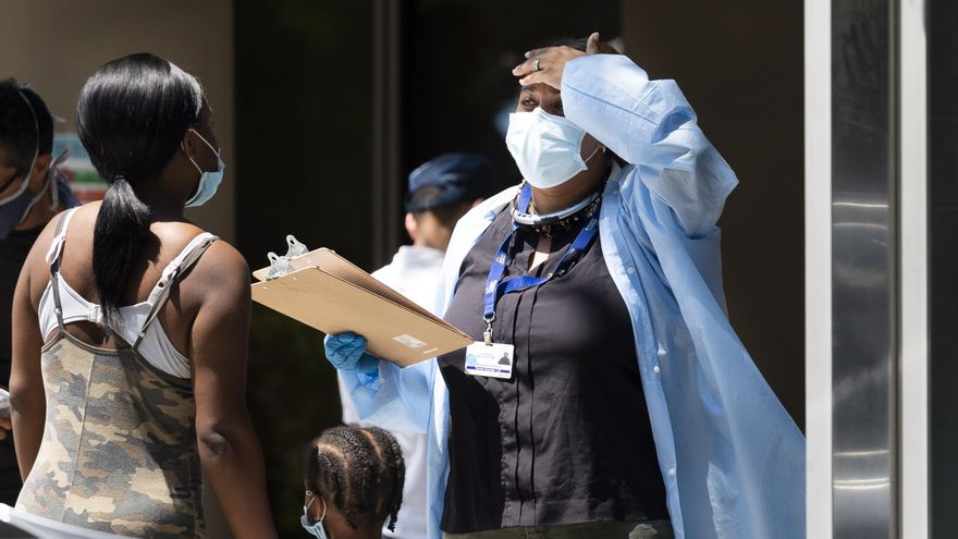 Una trabajadora de atención médica (d) habla con una paciente fuera de una zona de prueba COVID-19 administrada por la ciudad en Nueva York, Nueva York. EFE/EPA/JUSTIN LANE