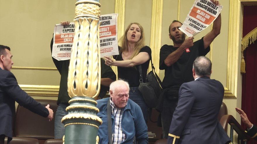 Personas muestran carteles en la tribuna de público del Congreso de los Diputados.