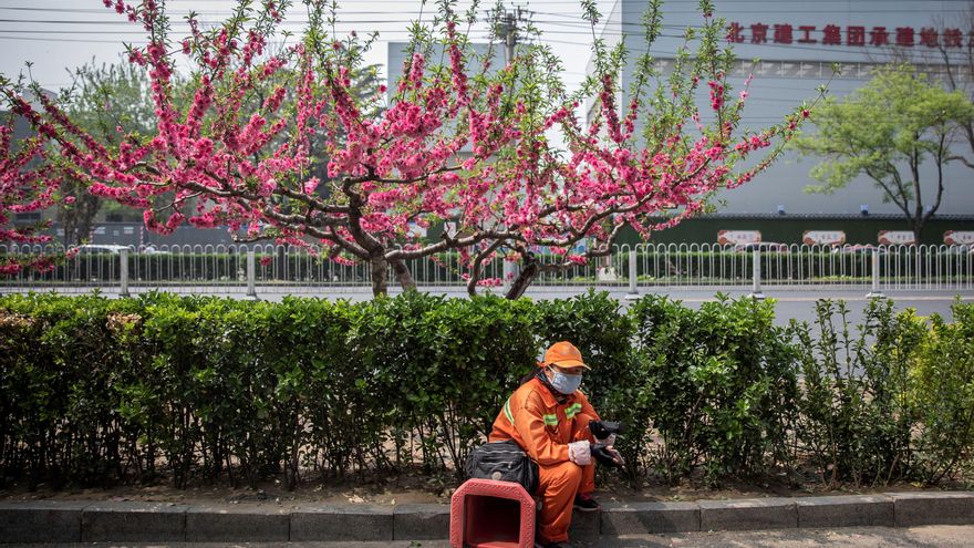 Un operario municipal se toma un descanso junto a una zona de obras en el distrito financiero de Pekín (China). EFE/ Roman Pilipey/Archivo