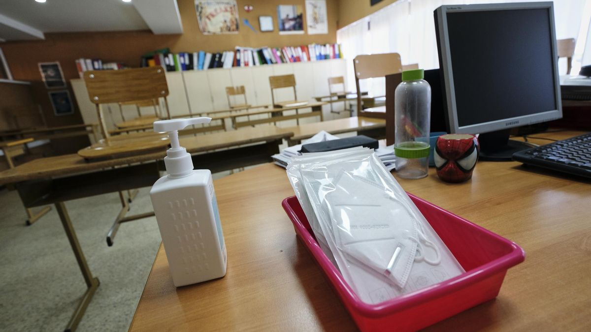 Mascarillas y gel desinfectante en la mesa de un profesor.