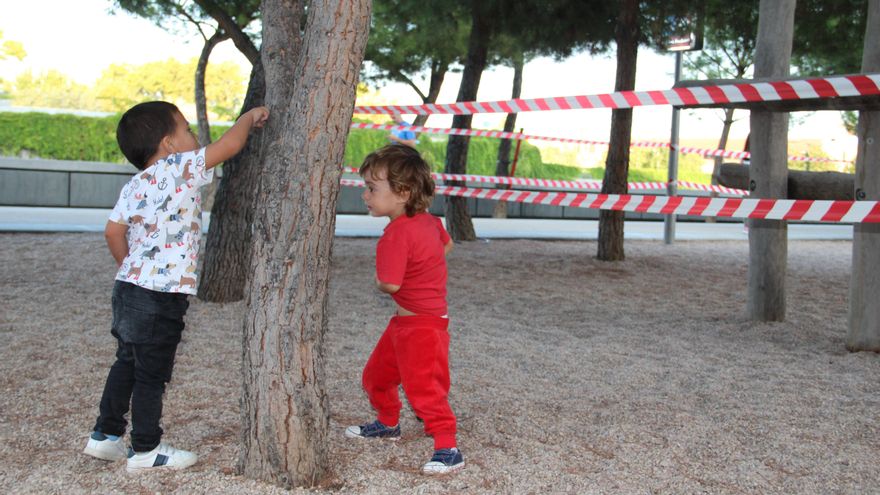 Samuel y Teo juegan alrededor del precinto de un parque infantil de Madrid Río, en el lado de Usera.