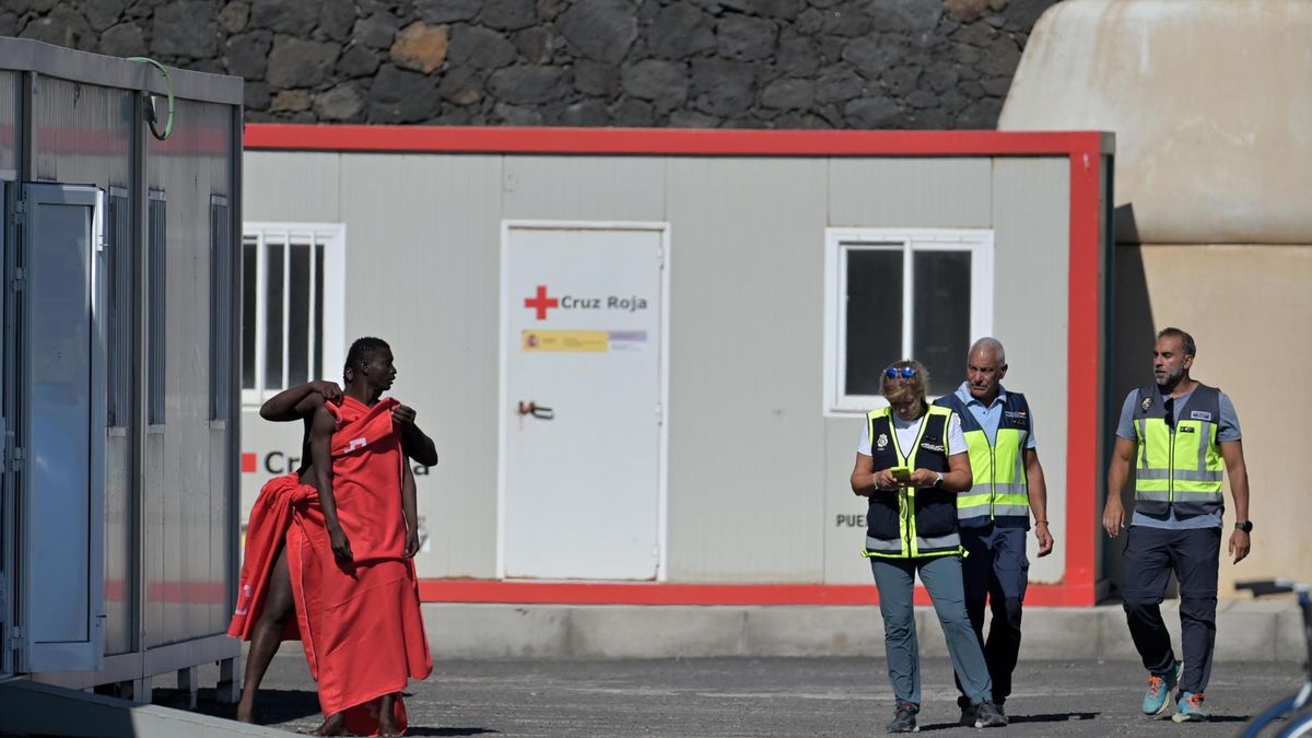 Dos de los 131 migrantes rescatados este sábado, por la embarcación de Salvamento Marítimo, Salvamar Navia, en aguas cercanas a El Hierro, son atendidos por los equipos de emergencia tras ser trasladados al puerto de La Restinga, en el municipio de El Pinar, en la isla de El Hierro. EFE/ Gelmert Finol