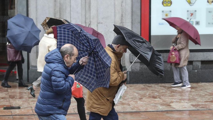 Un grupo de personas con paraguas este lunes en el centro de Oviedo.