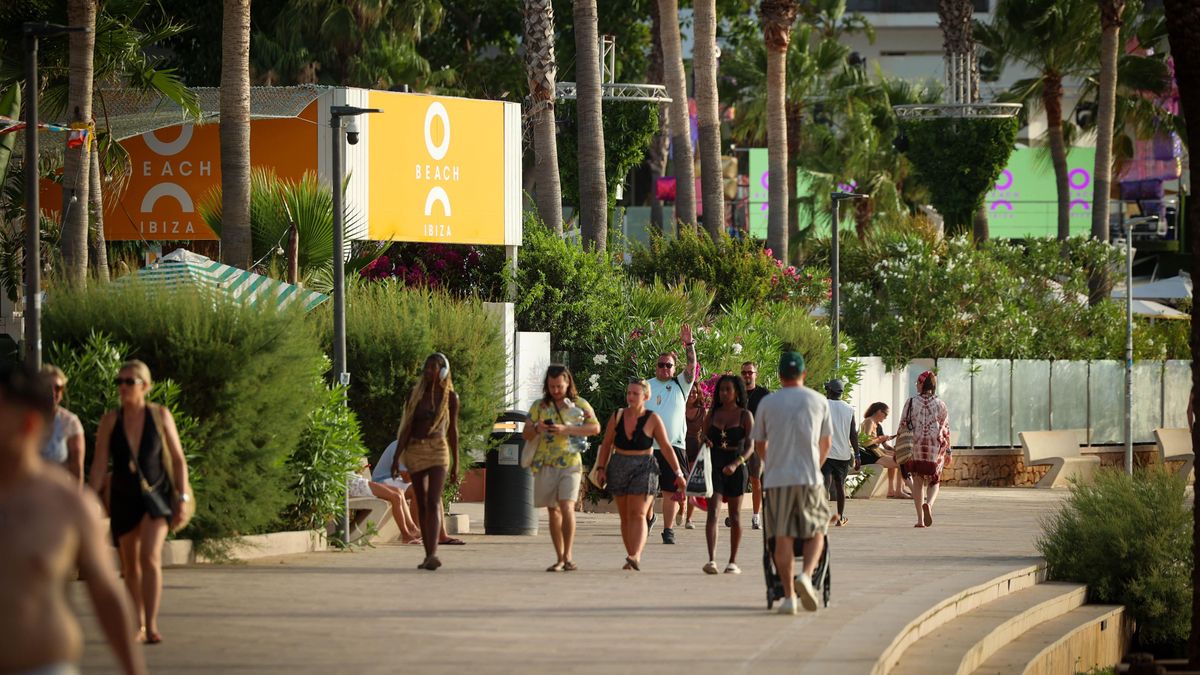 Turistas pasean junto a la entrada del 'beach club'
