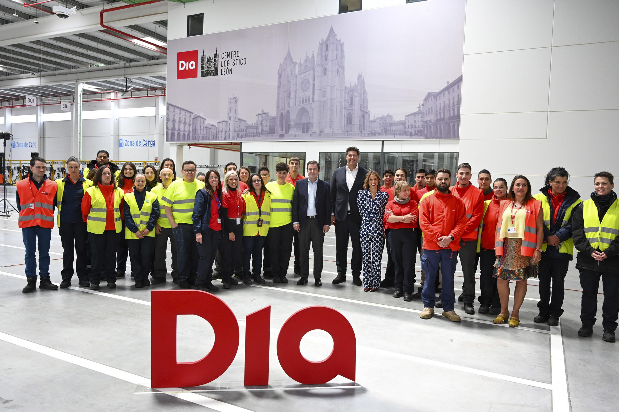 El presidente de la Junta, el directivo de Día España y trabajadores en el centro logístico inaugurado.