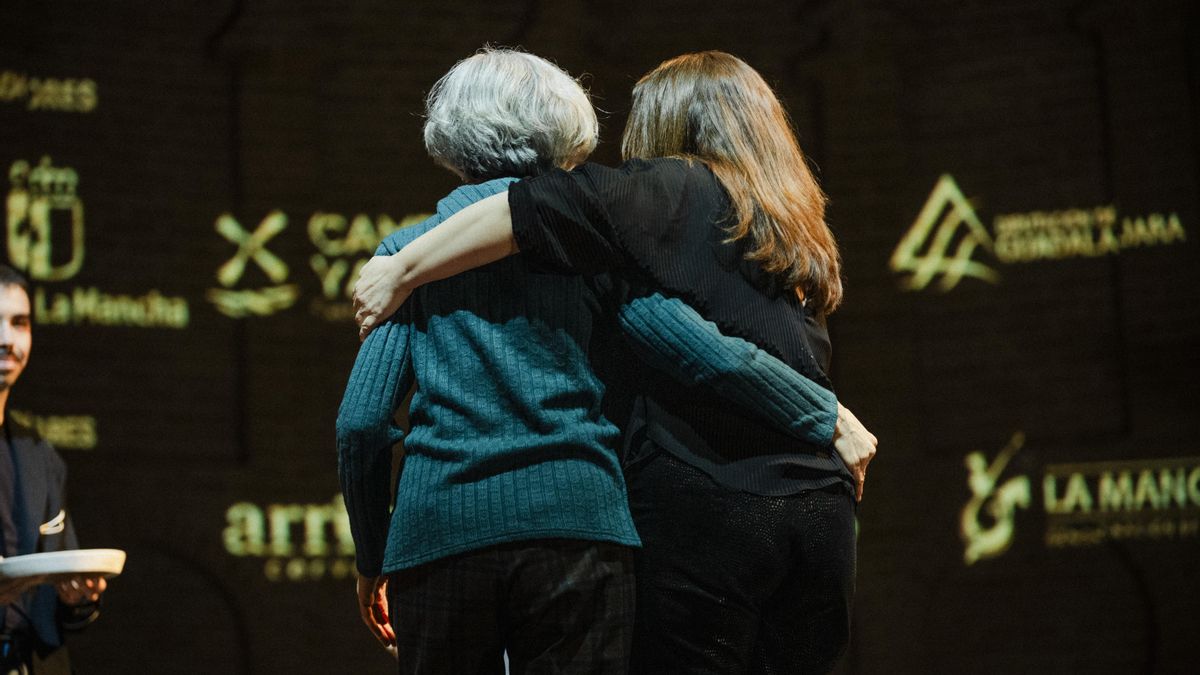 Carmen García Márquez, esposa de Francisco García Martín, sube al escenario junto a Carmen Bachiller, directora de elDiario.es Castilla-La Mancha, para recoger el reconocimiento póstumo para el historiador y articulista en el acto Reconocimientos Somos km.0