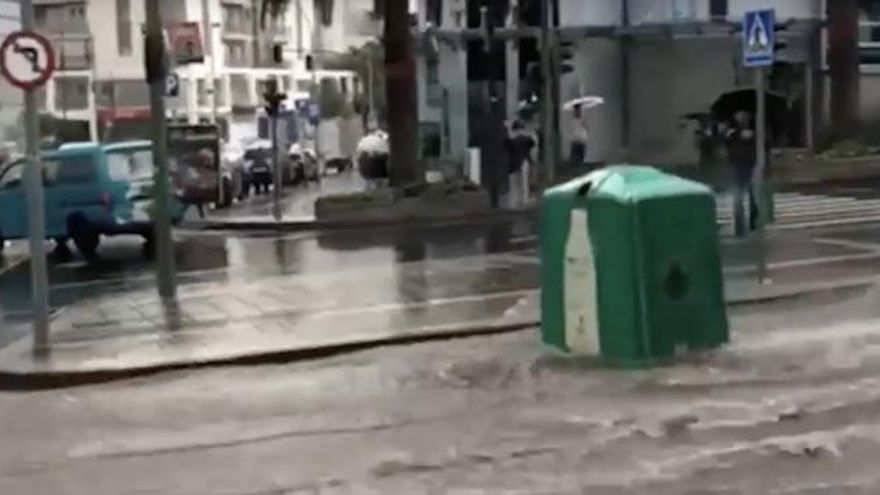 El agua arrastra un contenedor de reciclaje de vidrio por la capital tinerfeña