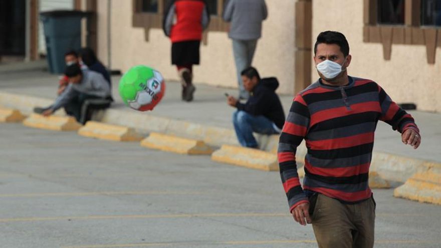 Un hombre juega fútbol con un tapabocas este viernes, en el Albergue Federal Leona Vicario, en la fronteriza Ciudad Juárez, en el estado de Chihuahua (México). Las autoridades de salud del estado mexicano de Chihuahua informaron este viernes de 72 casos de varicela en un centro integrador de migrantes en Ciudad Juárez, en la frontera de México con El Paso, Estados Unidos.