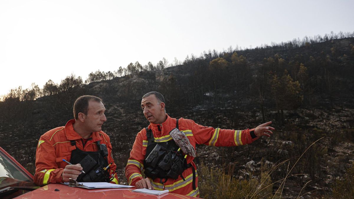 Dos bomberos en la zona incendiada a primera hora de este jueves.