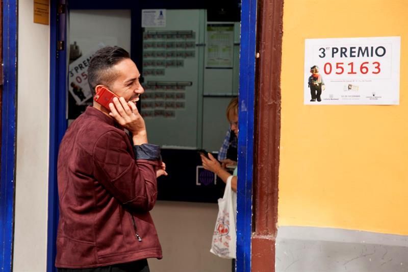 El propietario de la administración número 9 de Santa Cruz de Tenerife, Hari Satyani, conversa por teléfono, tras conocer que ha vendido por máquina un tercer premio del sorteo de la Lotería de Navidad