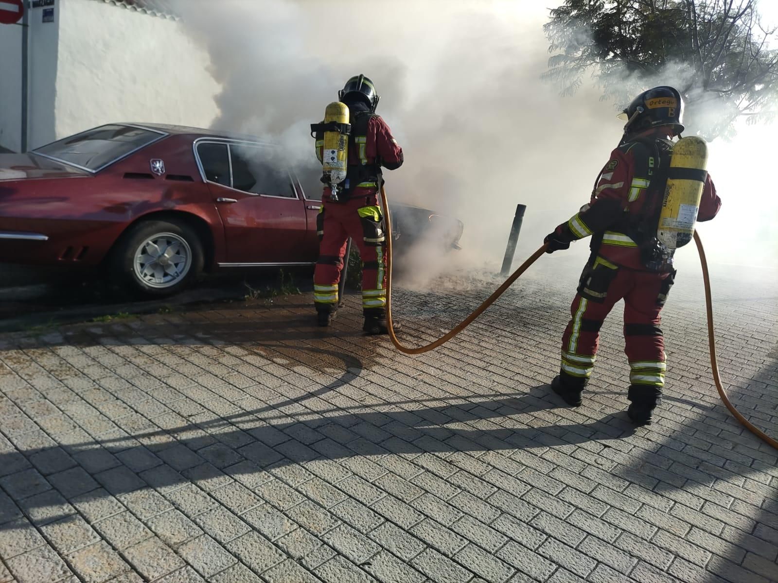 Efectivos del parque zonal de Vegueta colaboran para extinguir las llamas del vehículo. 