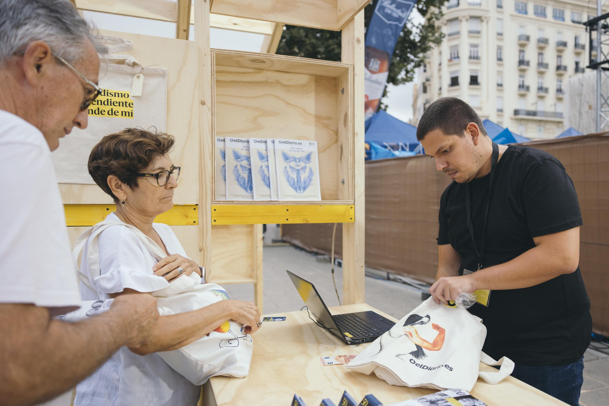 Varios lectores de elDiario.es se acercan al Quiosco habilitado en la Plaza del Ayuntamiento para apoyar al periodismo independiente de elDiario.es
