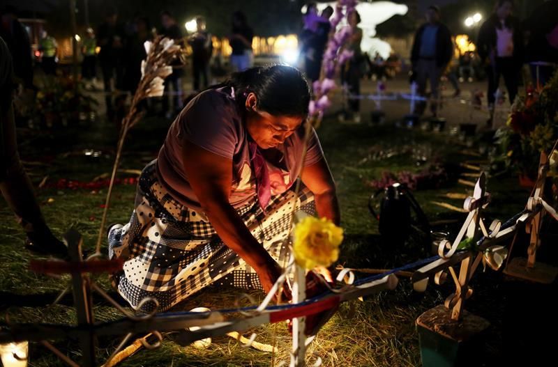 Ciudad de Guatemala (Guatemala). Un grupo de mujeres participaron en la noche del 7 de marzo en una vigilia por 41 niñas fallecidas en el incendio del Hogar Seguro Virgen de la Asunción hace un año, el 8 de marzo de 2017. En la foto, María del Carmen Urías, madre de una fallecidas, coloca velas en honor a las víctimas en un altar creado en el parque Central de la ciudad. EFE.