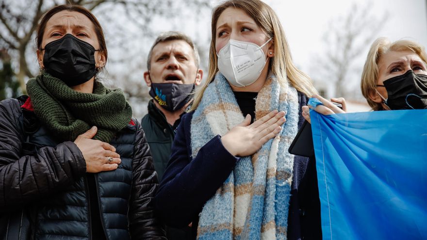 Varias personas cantan el himno de su país una concentración ante la embajada rusa en Madrid tras los primeros ataques rusos registrados en Ucrania.