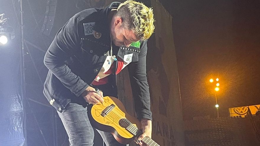 El artista Dani Martín firma la guitarra de un fan al finalizar su concierto