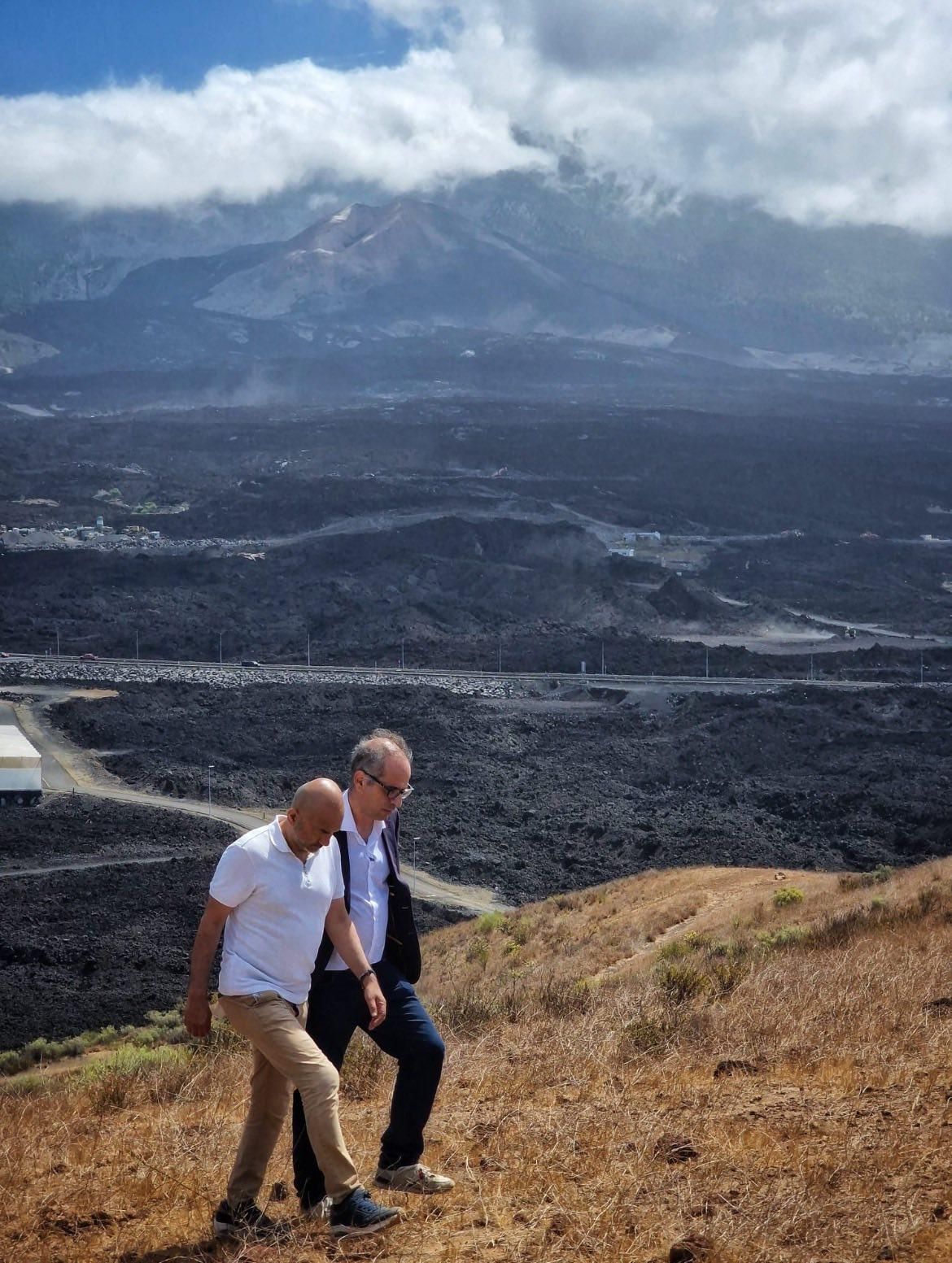 El comisionado especial para la Reconstrucción de La Palma, Héctor Izquierdo, con al famoso presentador  de la BBC Rajan Datar, con el volcán  Tajogaite y las coladas, al fondo.