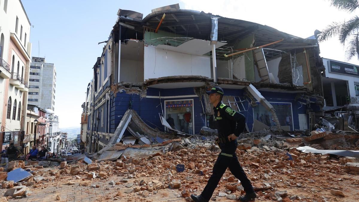 Un integrante de la Policía de Colombia camina frente a una edificación afectada tras un fuerte temblor este lunes, en Manizales (Colombia).