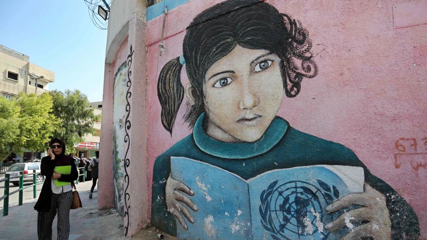 Una mujer pasa junto a un mural en una pared de la sede de la UNRWA en Ciudad de Gaza en 2018.