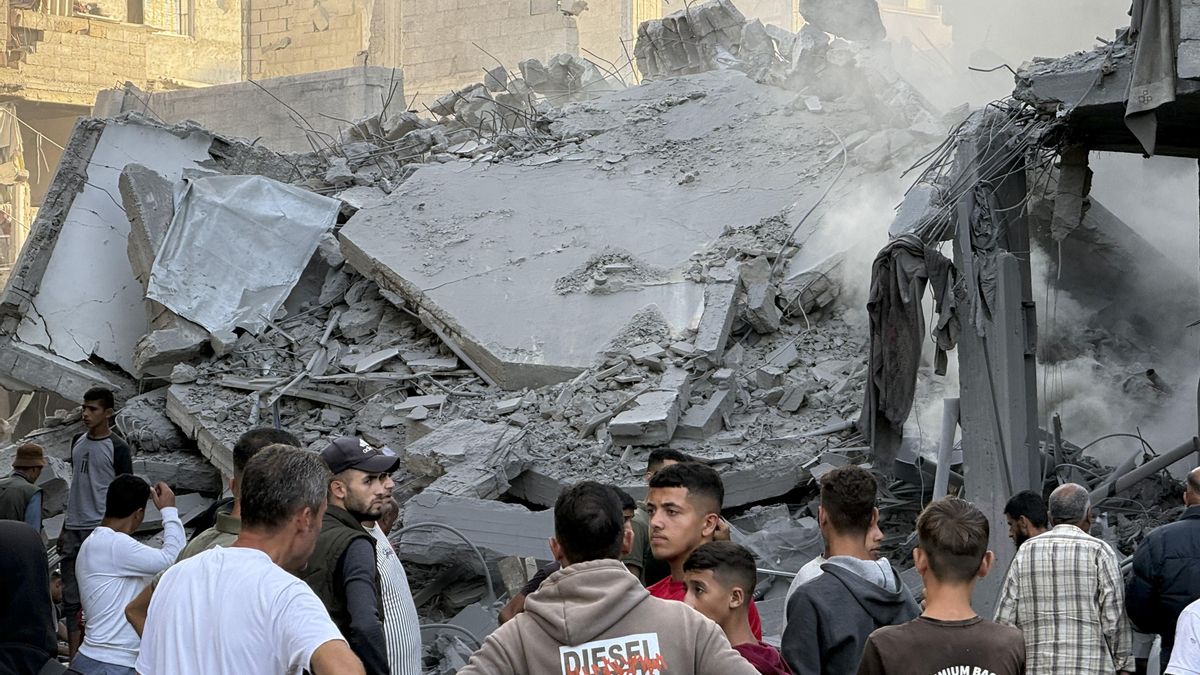 Varios hombres observan los escombros tras uno de los ataques lanzados el 19 de octubre por Israel en el campo de refugiados de Bureij, en el centro de la Franja de Gaza.