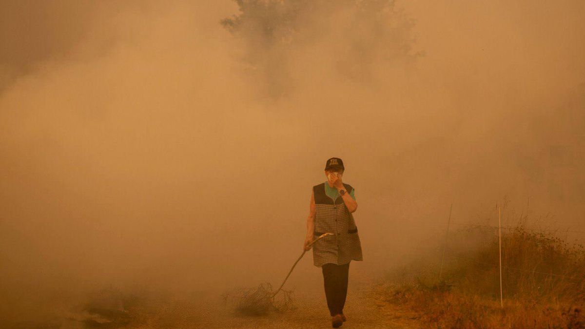 Una mujer se protege del humo durante los grandes incendios gallegos del verano de 2025
