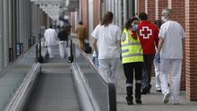 Varios sanitarios conversan mientras recorren una zona común, situada entre pabellones, en el Ifema
