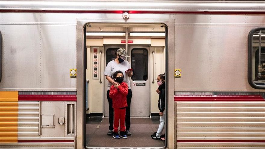 A family wearing face masks enter the subway at the Pershing Square metro station amid the coronavirus pandemic in Los Angeles, California, USA, 02 April 2020.