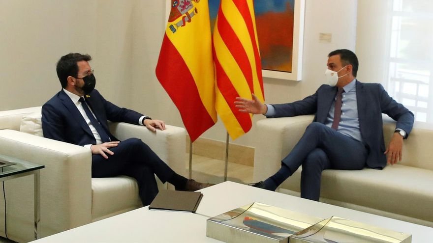 El presidente del Gobierno, Pedro Sánchez (d), conversa con el presidente de la Generalitat, Pere Aragonès, durante su encuentro este martes en el Palacio de la Moncloa.