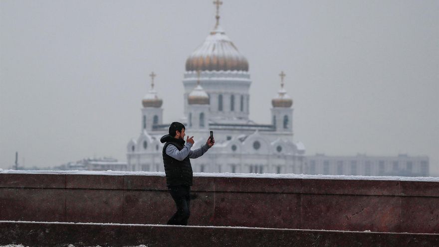 RUSIA CORONAVIRUS: MOSCÚ, 07/02/2022.- Un hombre sostiene su teléfono móvil frente a la catedral de Cristo Salvador, este lunes en Moscú. De acuerdo con las autoridades sanitarias, en las últimas 24 horas se han detectado un número récord de 171.905 casos de covid en Rusia.