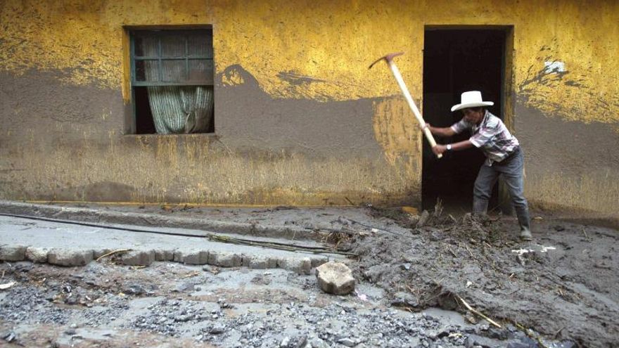 Un campesino retira lodo de su casa, en una de las calles principales de la localidad de San Antonio Senahú.