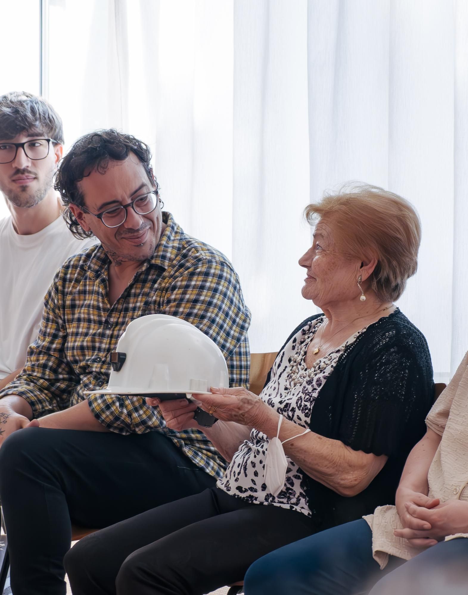 Un asistente hablando con una señora durante el encuentro intergeneracional en el Centro Social para Personas Mayores El Llano, en Gijón.