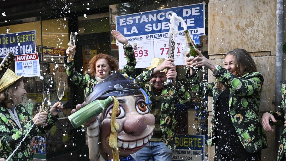 Empleados de una administración de lotería de Oviedo celebran tras haber vendido décimos del 90693, el tercer premio, y del 77715, uno de los quintos premios