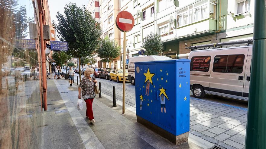 Un vecina pasea por las calles de La Inmobiliaria en Torrelavega.