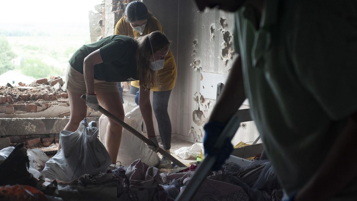 Voluntarios limpian los escombros de un edificio residencial en la ciudad de Hostomel, al noroeste de Kiev.