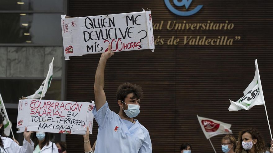Un sanitario muestra una pancarta en señal de protesta frente al Hospital Valdecilla de Santander.
