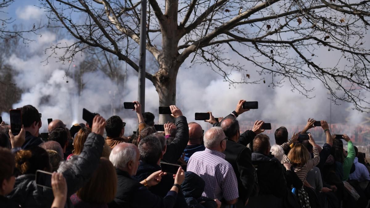 Varias personas viendo y grabando el humo de la primera mascletá madrileña.