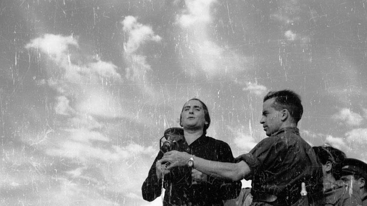 Mitin de Dolores Ibárruri a las tropas en Brunete, Francisco Antón sujeta el micrófono en 1937.