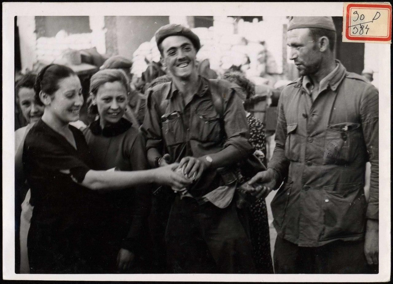 "Muchachas repartiendo a los soldados botes de leche condensada que por la mañana rescataron de los rojos". 24 de agosto de 1937